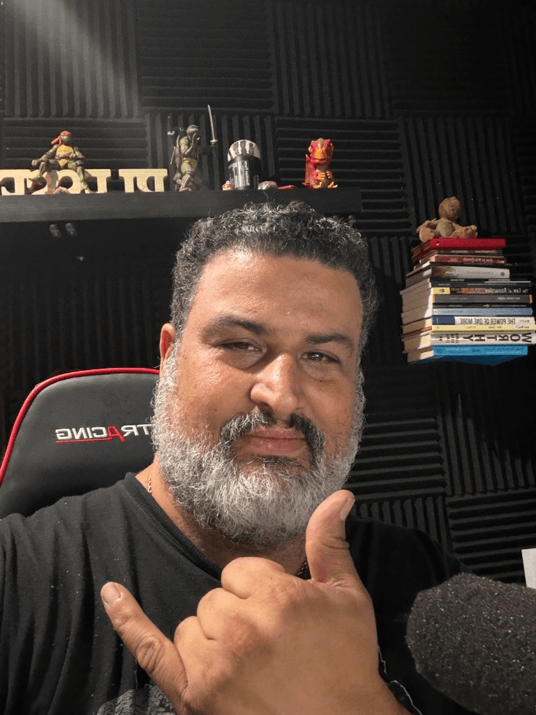 Giuseppe in the booth with a warm smile and hang-loose gesture